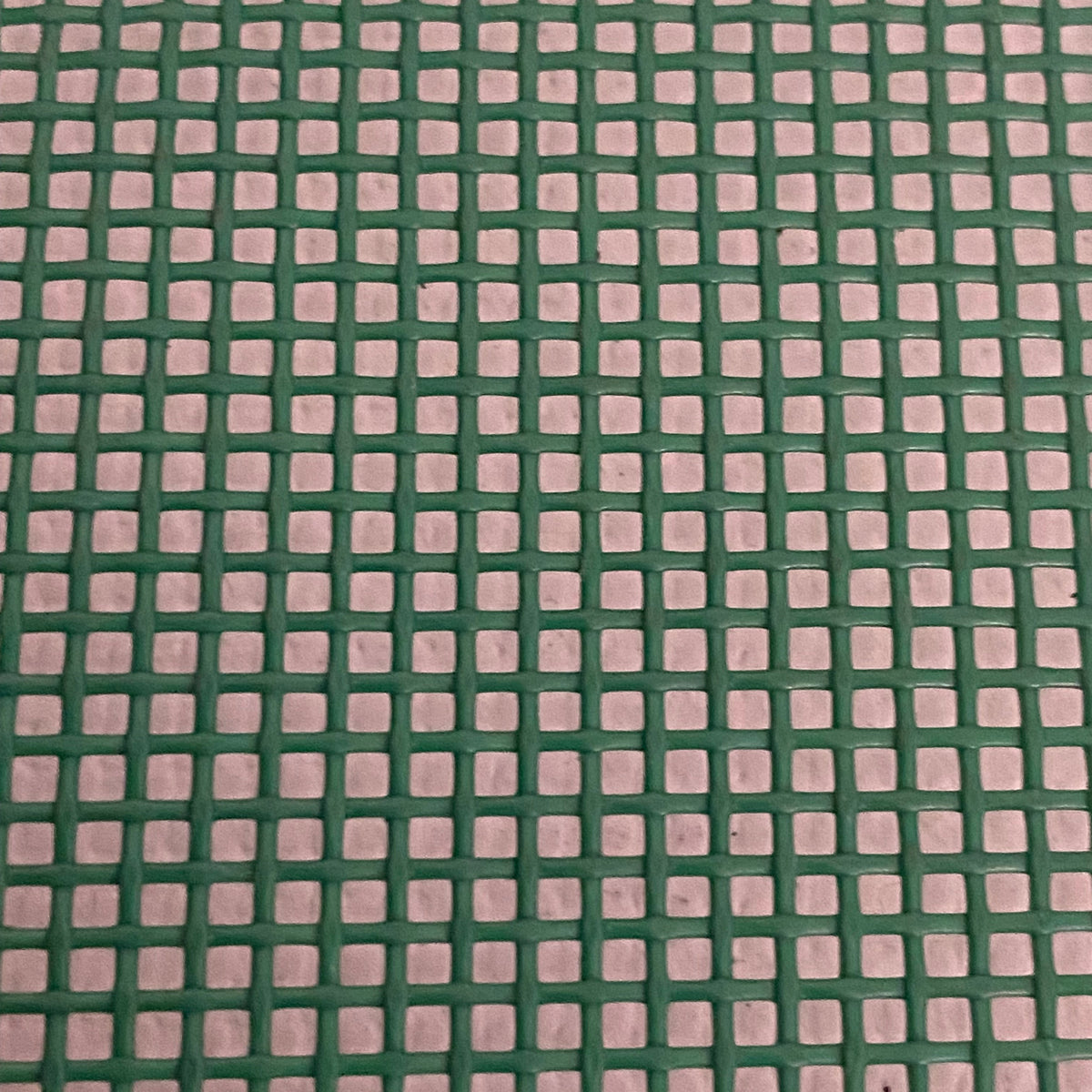 Close-up view of a heavy-duty green mesh tarp made of UV-resistant polyester, featuring a pattern of square openings.