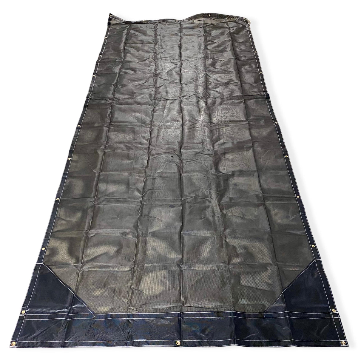 Top side of a black mesh tarp laid out on the floor showing the vinyl reinforced edges and even grommet spacing.