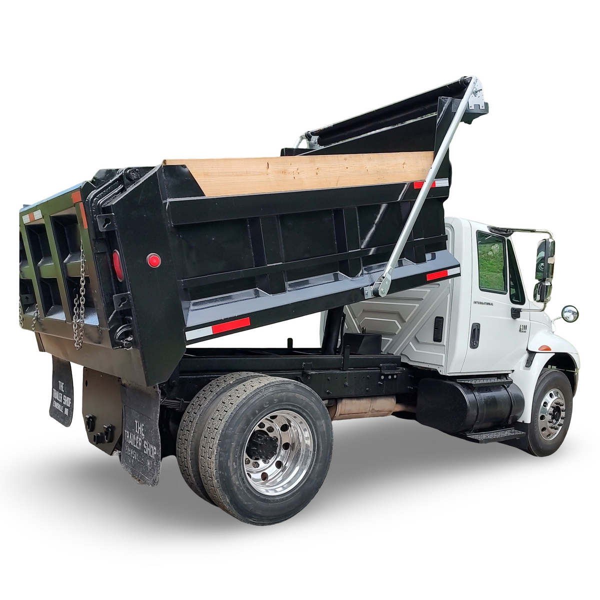 Dump truck with an open bed on a white background with a patriot aluminum electric tarp system installed on it.