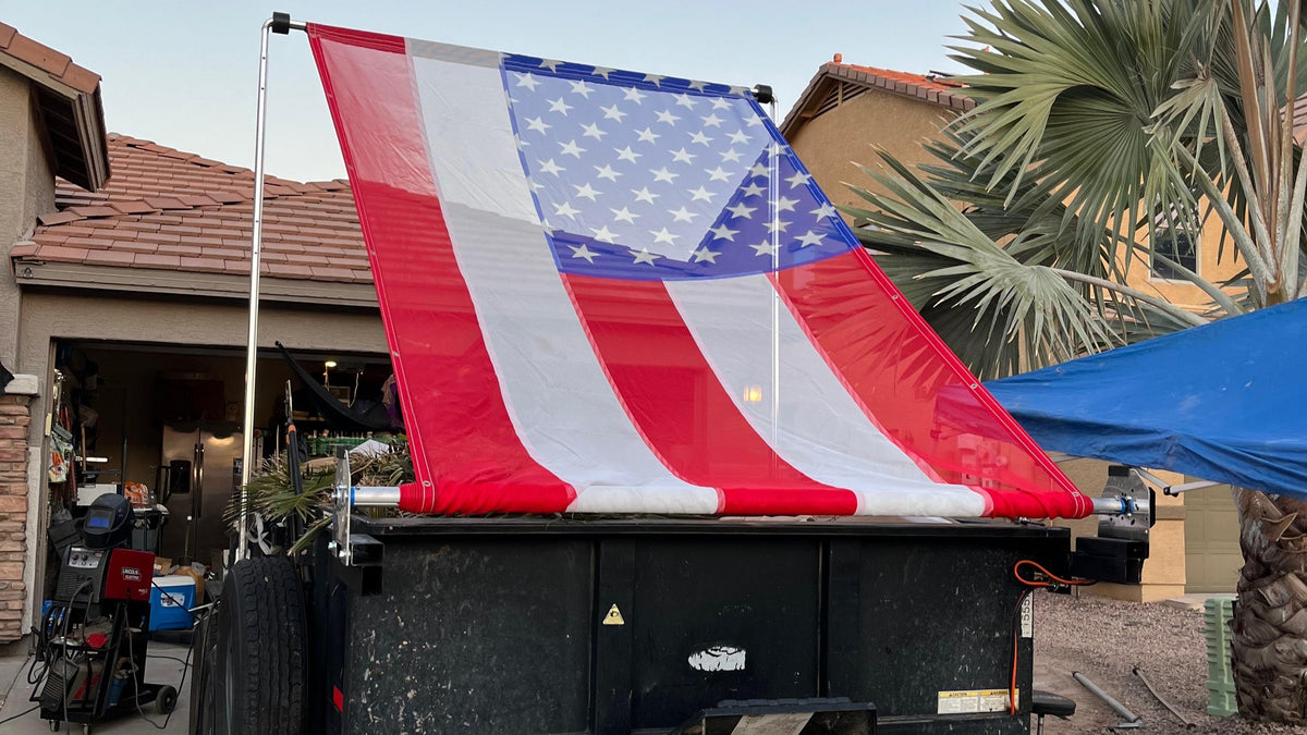 Dump trailer with American flag cover in a residential area
