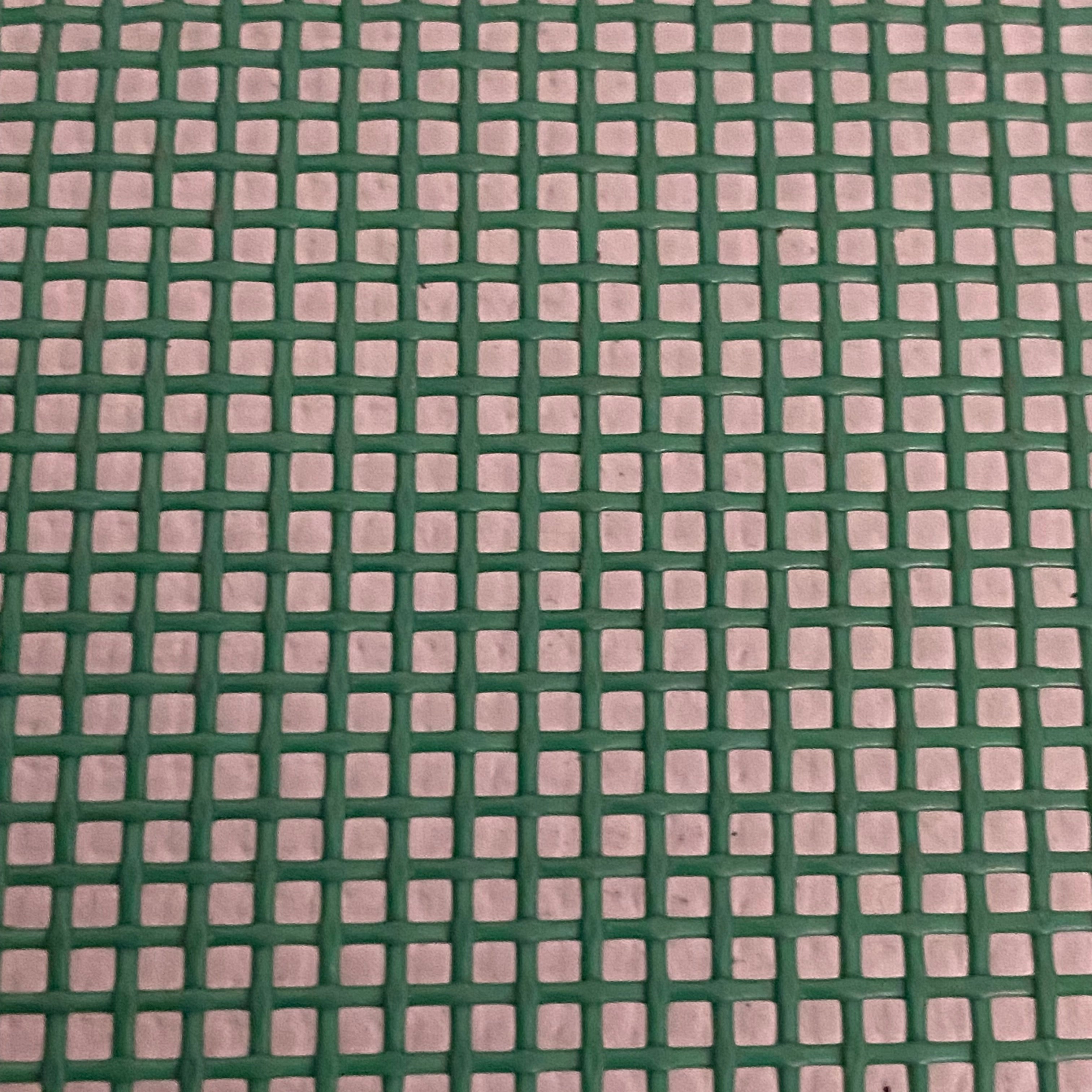 Close-up view of a heavy-duty green mesh tarp made of UV-resistant polyester, featuring a pattern of square openings.