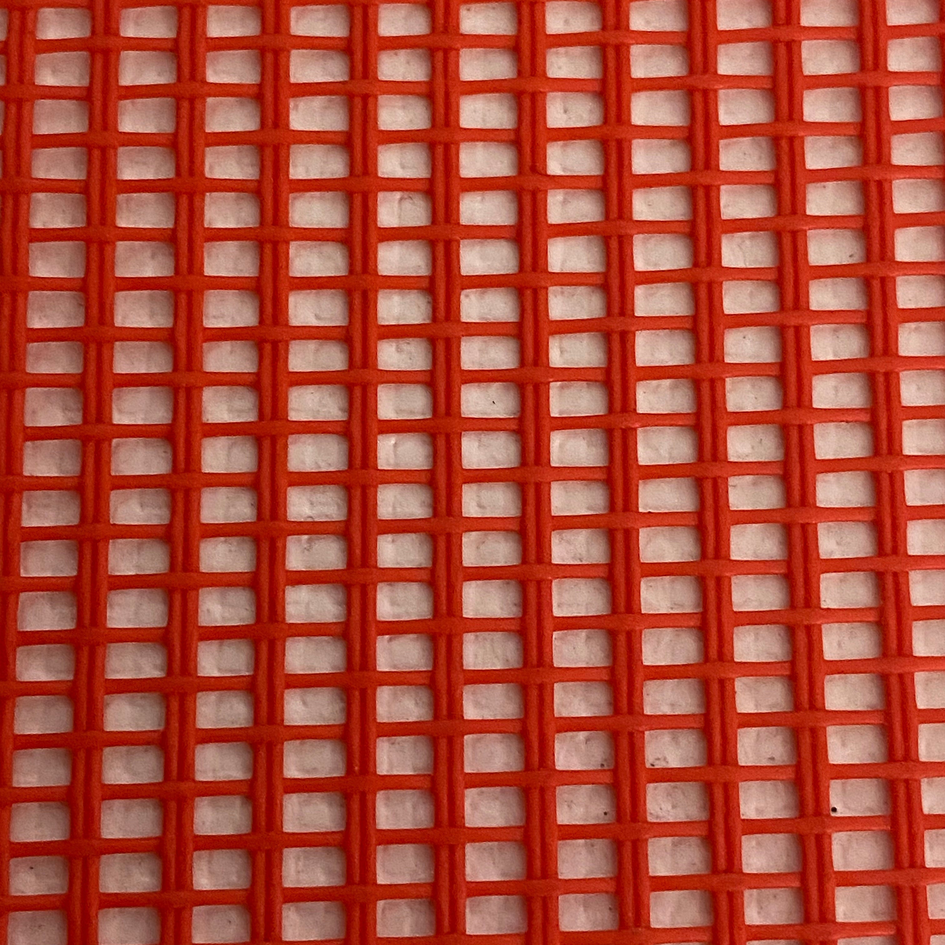 Close-up view of a heavy-duty red mesh tarp made of UV-resistant polyester, featuring a pattern of square openings.