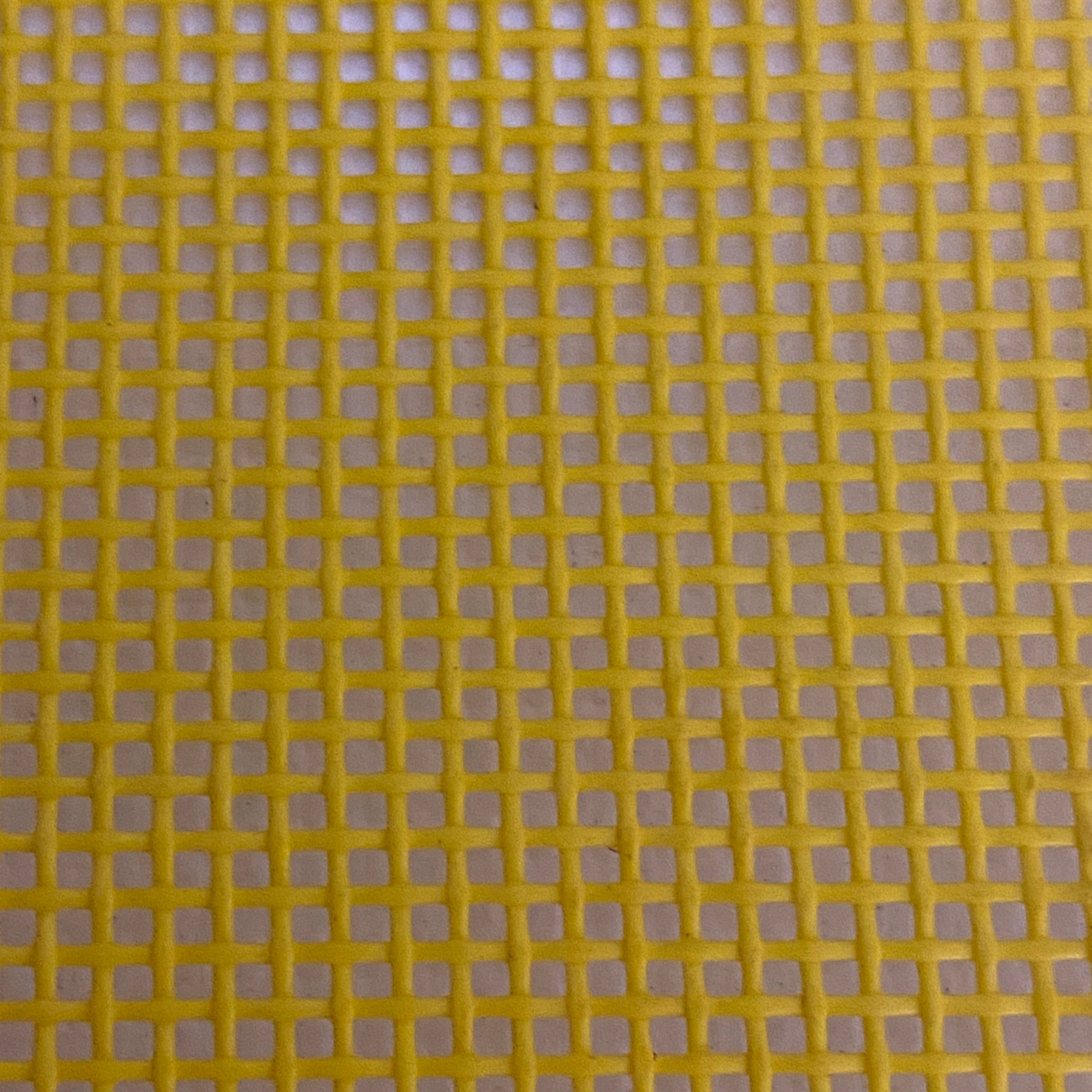 Close-up view of a heavy-duty yellow mesh tarp made of UV-resistant polyester, featuring a pattern of square openings.